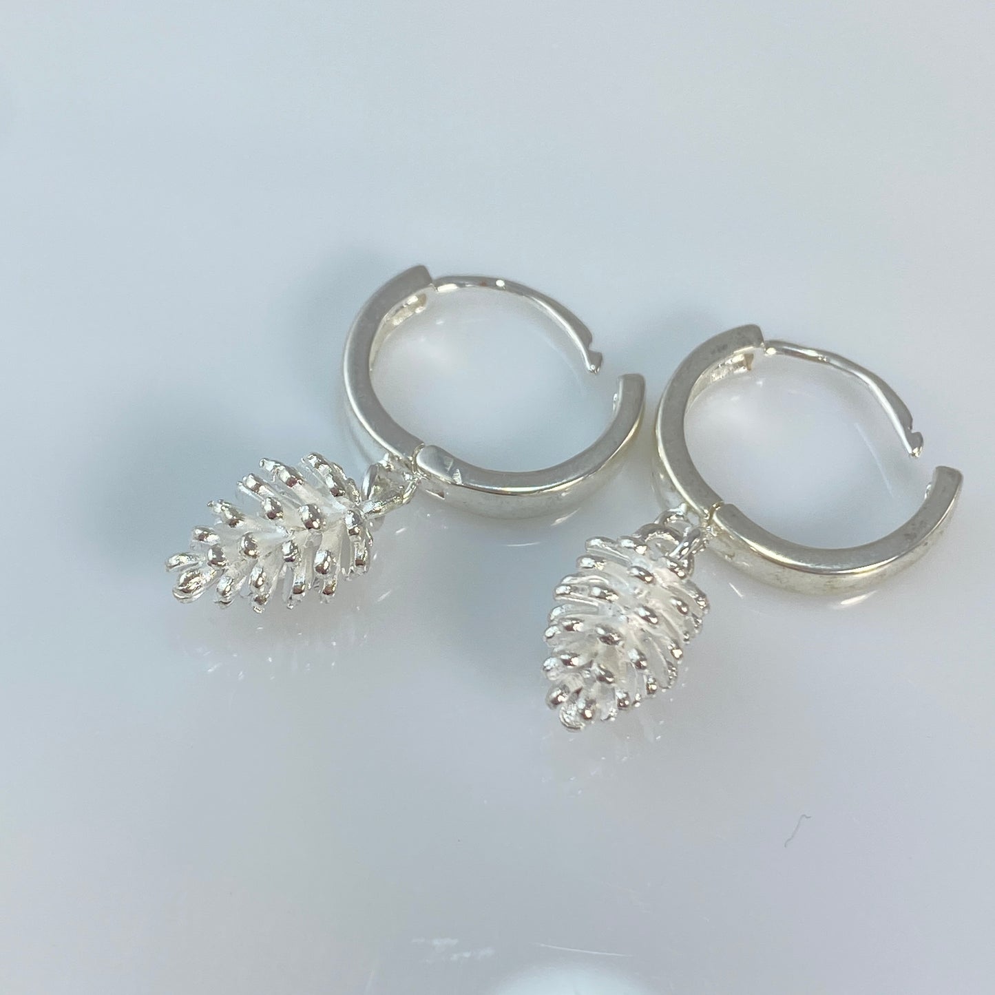 Boucles d'oreilles créoles en laiton plaqué platine avec pommes de pin argentées
