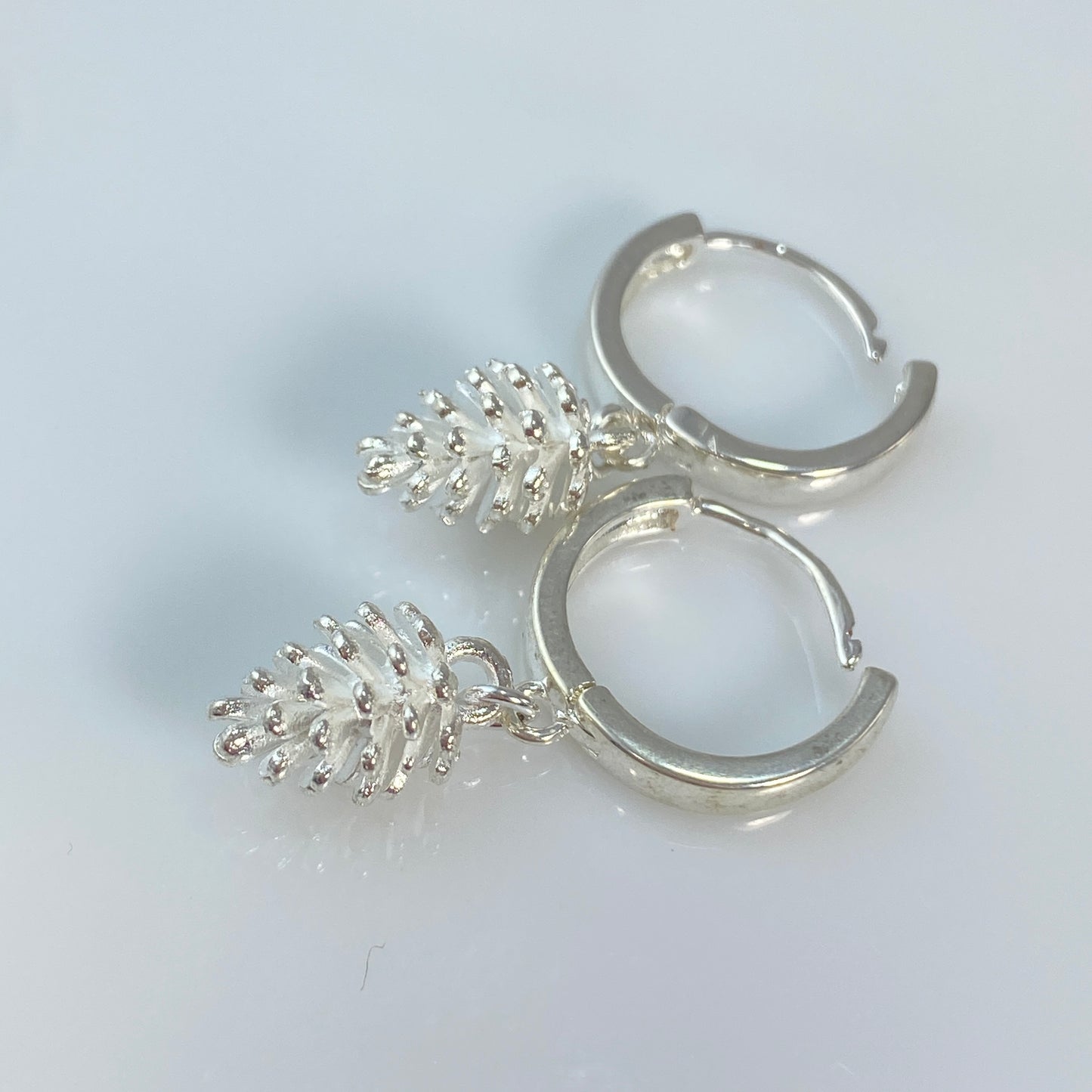 Boucles d'oreilles créoles en laiton plaqué platine avec pommes de pin argentées