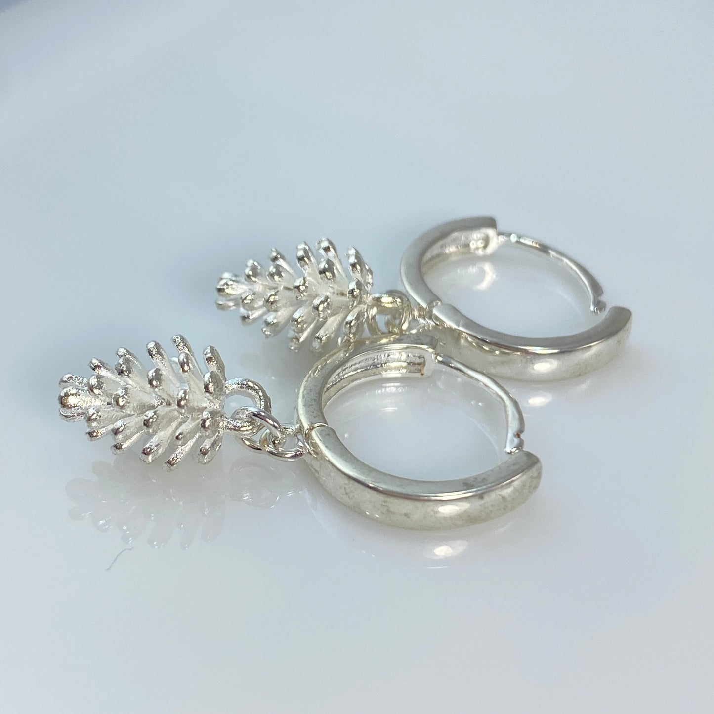 Boucles d'oreilles créoles en laiton plaqué platine avec pommes de pin argentées