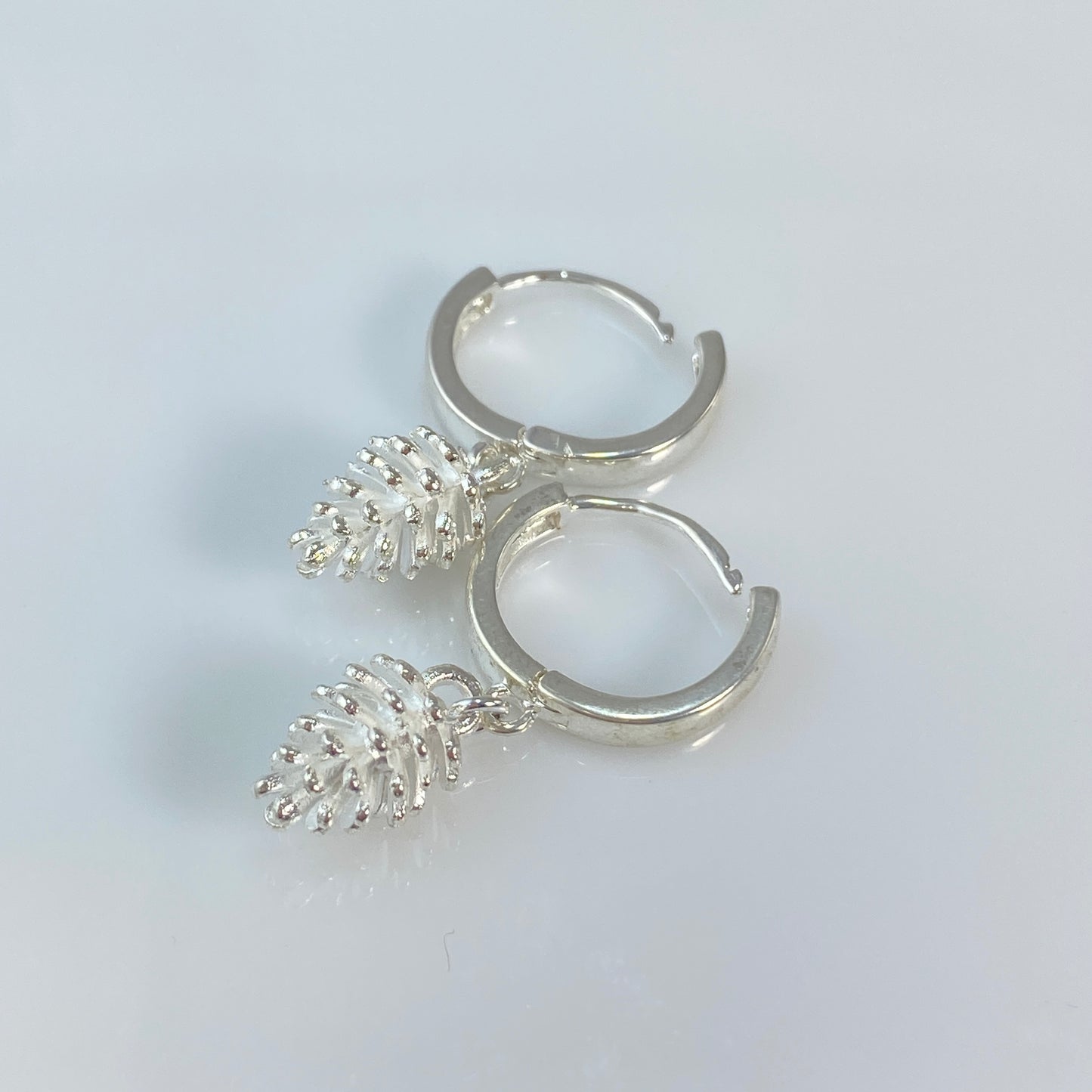 Boucles d'oreilles créoles en laiton plaqué platine avec pommes de pin argentées