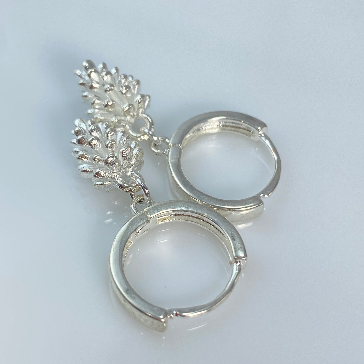 Boucles d'oreilles créoles en laiton plaqué platine avec pommes de pin argentées