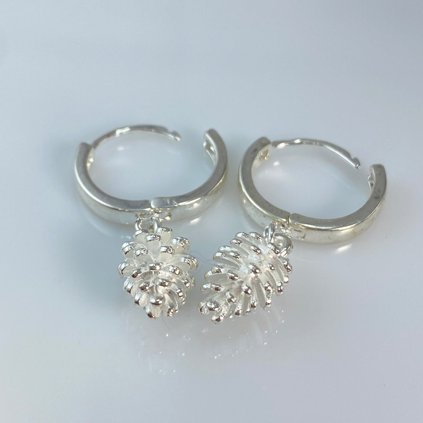 Boucles d'oreilles créoles en laiton plaqué platine avec pommes de pin argentées